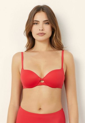 Seno rosso push-up con coppe lisce, spalline sottili e regolabili, e un piccolo dettaglio a taglio al centro. Tessuto morbido e elastico.