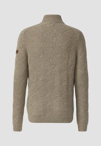 Beige gebreide trui met een textuurpatroon, hoge kraag en geribde zoom. Bevat een klein logopatch op de linkermouw.