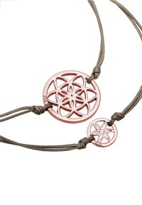 Collar de pendant en oro rosa que presenta un gran charm circular con un intrincado diseño floral recortado, acompañado de un charm más pequeño, sobre un cordón trenzado.