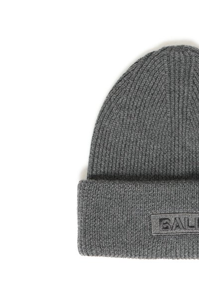 Pelēka adīta cepure ar saliektu malumu un taisnstūra izšuvumu uz maluma, daļēji redzams teksts "BOLA".