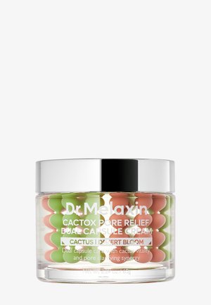 Frasco transparente con tapa plateada que contiene cápsulas verdes y naranjas, etiquetado como Dr. Melaxin Cactox Pore Relief Dual Capsule Cream.