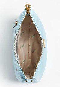 Borsa a pochette sintetica liscia di colore azzurro chiaro con una cerniera dorata, dotata di un interno beige foderato con un motivo stampato ripetuto del logo "GUESS".