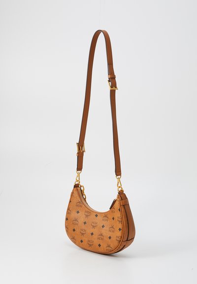 Sac à bandoulière en cuir marron avec sangle réglable, quincaillerie dorée, fermeture éclair et motif logo MCM répété sur le corps incurvé.