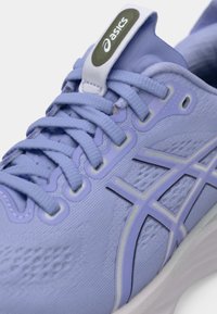 Scarpa da ginnastica viola chiaro con tomaia in rete testurizzata, punta arrotondata, occhielli rinforzati e suola bianca. Presenta il logo sulla linguetta e strisce laterali.