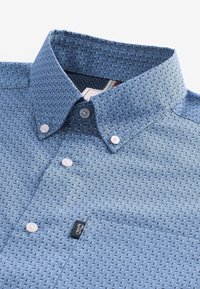 Lichtblauw patroonshirt met een button-down kraag, parelmoeren knopen en een klein logo-label nabij de zak. Gestructureerde stof met diamantvormen.