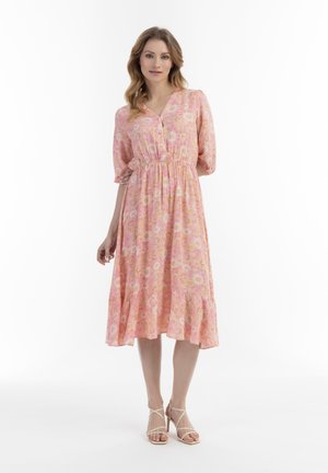 Rotes Blumenkleid mit V-Ausschnitt, kurzen Puffärmeln, elastischem Taillenbund und gerüschtem Saum, hergestellt aus einem leichten Stoff.