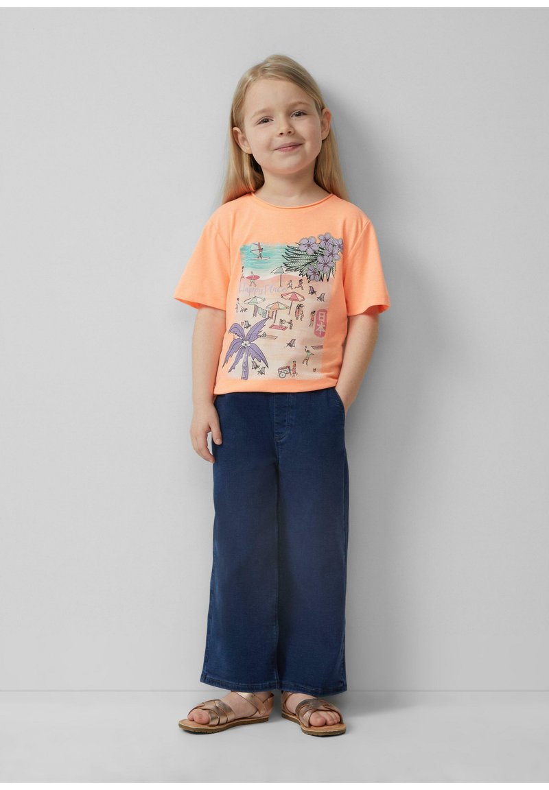 Heldere oranje korte mouwen t-shirt met strandscène grafiek, gecombineerd met donkerblauwe wijd uitlopende jeans en bruine sandalen met banden.