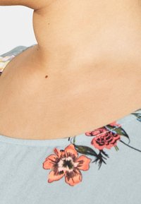 Sukienka w kwiatowy wzór z okrągłym dekoltem, wykonana z miękkiego materiału w kolorze niebieskim, ozdobiona pomarańczowymi, różowymi i zielonymi kwiatami na brzegach.