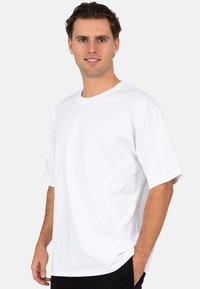 Witte korte mouwen T-shirt van katoen met een ronde hals, losse pasvorm en een gladde textuur. Eenvoudig ontwerp, geen zichtbare patronen of accenten.