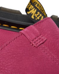Sapatilha de couro fúcsia com superfície texturizada, costura detalhada e um puxador amarelo e preto. Apresenta um design de sola robusto.