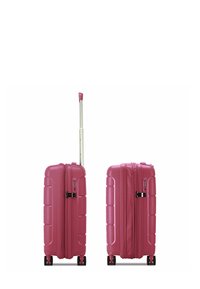 Valigia rigida rosa con superficie testurizzata, doppie cerniere, lucchetto a combinazione e maniglia telescopica montata su quattro ruote.