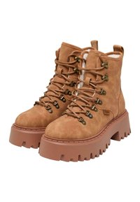 Bottes de randonnée en daim marron avec une semelle en caoutchouc épaisse, dotées d'œillets métalliques et de lacets, ainsi qu'une doublure en fourrure douce pour plus de chaleur.