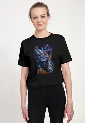 T-shirt noir avec un imprimé graphique coloré représentant un vaisseau spatial sur un fond cosmique avec des étoiles et des planètes.