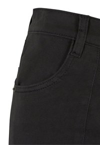 Pantaloni in tessuto nero con tasca frontale con dettagli di cucitura, texture liscia e design della vita aderente.