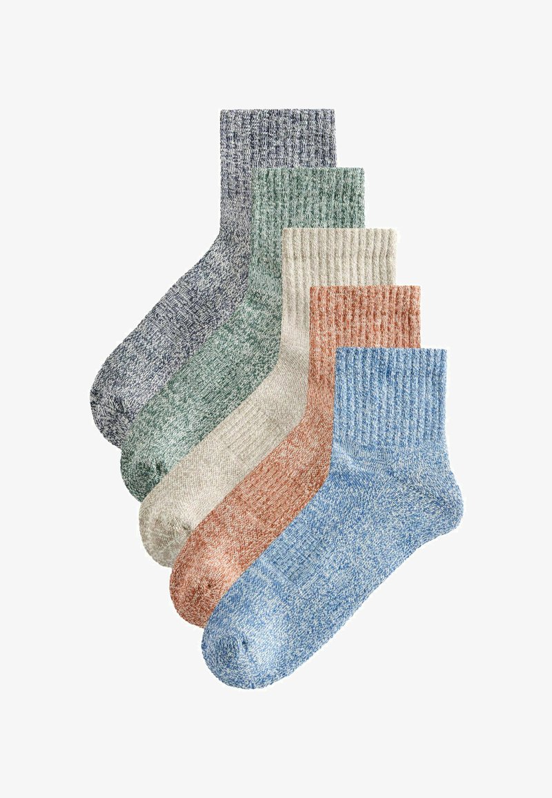 Cinq paires de chaussettes à côtes montantes en bleu, rouille, beige, vert et gris, disposées en chevauchement sur un fond blanc.
