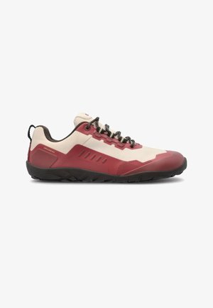 Sneaker basso profilo con tomaia rossa e beige, suola nera, lacci neri e linguetta sul tallone, progettata per uso outdoor o casual.