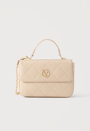 Bēšs pārgabala soma ar augšējo rokturi, zelta aplis logotips centrā un noņemams zelta ķēdes siksniņa uz balta fona.