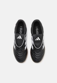 Black leather soccer shoes with white stripes, textured surface, round toe, and gum rubber outsole. Laces and cushioned inside for comfort.