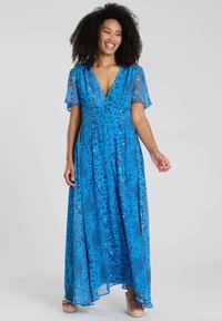 Maxikleid in lebhaftem Blau mit Leopardenmuster. Verfügt über kurze, halbtransparente Flatterärmel, einen V-Ausschnitt und einen fließenden Rock.