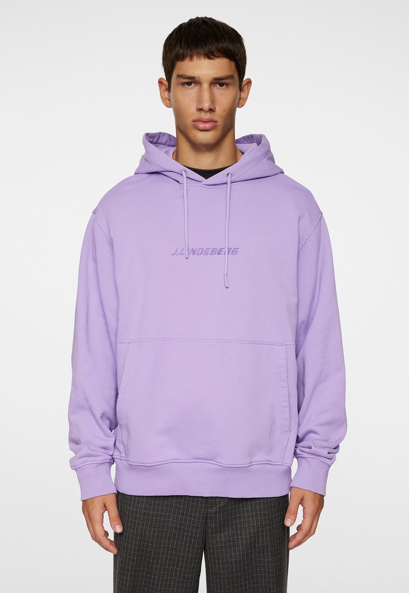 Lilla hoodie med en frontlomme, snorhue og broderet logo. Lange ærmer og ribstrikkede manchetter fuldender det afslappede design.