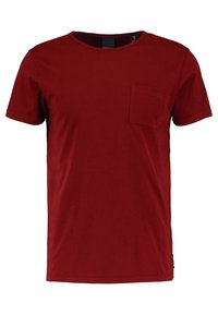 Camiseta de algodón roja con escote redondo, mangas cortas y un bolsillo en el pecho izquierdo. Textura suave, ajuste casual y sin patrones visibles.