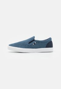 Instap schoenen van denimstof in donkerblauw, met een witte rubbere zool en marineblauwe accentdetails op de hiel. Voorzien van elastische zijkanten.