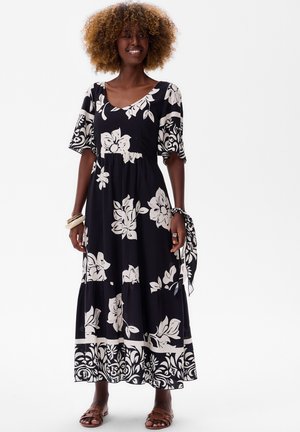 Maxi-jurk van zwarte stof met witte bloemenpatronen, scoop halslijn en korte mouwen. Bevat een gathered taille en een vloeiende rok.