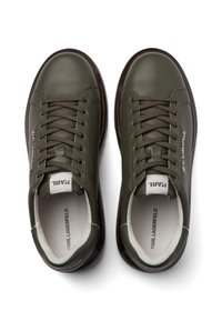 Sneakers in pelle verde oliva con punta rotonda, design con lacci e rivestimento interno bianco. Presentano un logo discreto sul lato e una suola scura lucida.