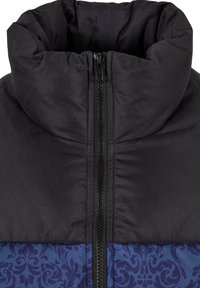 Čierna nafukovacia bunda s vysokým golierom, predným zipsom a textúrovanou tmavomodrou vzorovanou spodnou časťou. Hladký, izolovaný materiál.