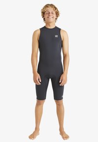Un traje de neopreno negro con piernas cortas, diseño sin mangas, costuras planas y un pequeño logo en el pecho, adecuado para deportes acuáticos.