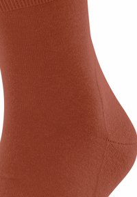 Braune Knöchelsocke aus glattem, dehnbarem Stoff mit geripptem Bündchen und nahtloser Zehenpartie, die eine einheitliche, gleichmäßige Textur aufweist.