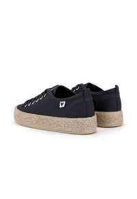 Baskets noires en toile avec bouts ronds, lacets et semelles en jute texturé. Présente une petite étiquette logo sur le côté.