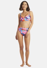 Zestaw bikini z kolorowym, abstrakcyjnym wzorem w odcieniach różu, niebieskiego i pomarańczowego. Górna część ma usztywnioną konstrukcję z regulowanymi ramiączkami; majtki o wysokim stanie.