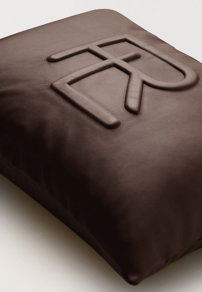 Brun läderpåse med en upphöjd logotypdesign på ytan. Texturen verkar slät och lätt blank, med en fyrkantig form.
