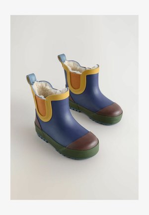 Modré gumové čižmy s žltými a oranžovými akcentmi, hnedými špičkami a textúrovanými zelenými podrážkami. Vnútri sú podšité bielym umelým kožúškom pre teplo.