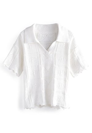 Polo blanc en maille avec col en V, manches courtes, ourlet festonné et motifs texturés sur toute la surface. Fabriqué en tissu léger.
