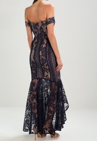 Navyblå spets mermaidklänning med off-shoulder ärmar, blommönster, transparent tyg och utsvängd nederdel. Slät textur, elegant design.