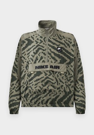 Nike Air pullover jacket in green camo pattern. Features a high collar, half-zip front, and a front pocket with embroidered logo detail.