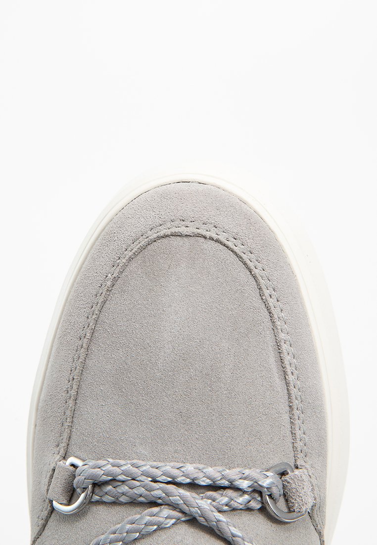 Graue Wildleder-Sneaker mit rundem Zehenbereich, aufwendiger gestickter Verzierung und geflochtenen grauen Schnürsenkeln, auf einer weißen Gummisohle.