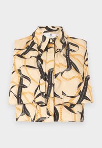 Μπεζ αμάνικη μπλούζα με μαύρη κορδέλα και σχέδιο με χρυσή αλυσίδα, με γιακά σε σχήμα αιχμής και πιέτες στο μπροστινό μέρος.