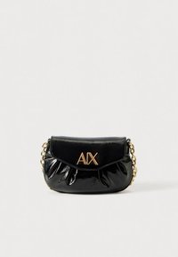 Czarna torebka z lakierowanej skóry ze złotym łańcuszkiem na ramię, złożoną klapką i logo "AIX" na przodzie. Kompaktowy i zaokrąglony kształt.
