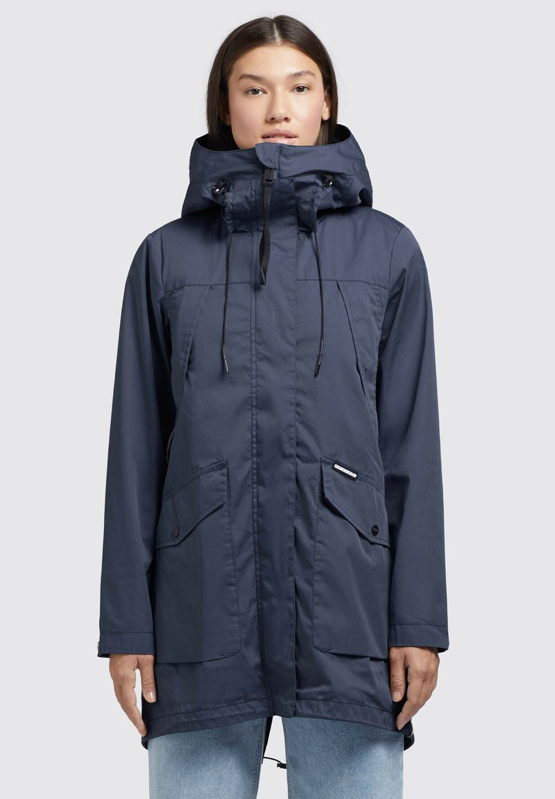 Giacca impermeabile blu navy con colletto alto, cappuccio regolabile, due tasche frontali e lacci regolabili in vita e sull'orlo.