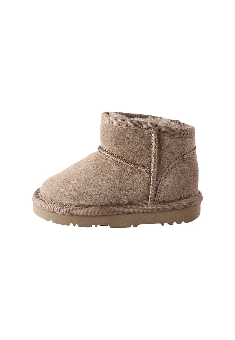 Beige mockask ankleboots med mjukt foder, rund tå och förstärkt söm. Platt gummisula med texturerat greppmönster.