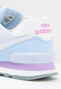 Baskets bleu clair avec une tige blanche perforée, un logo "new balance" rose, et une semelle multicolore avec des accents violets.
