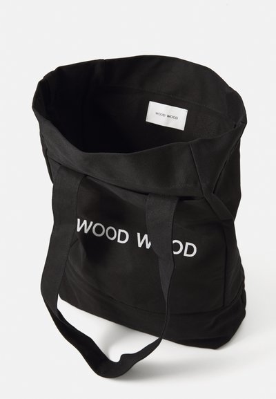 Musta kangastoot suurte valgete tähtedega "WOOD WOOD". Omab vastupidavat kangast, kahte pikka käepidet ja avatud linnustust.