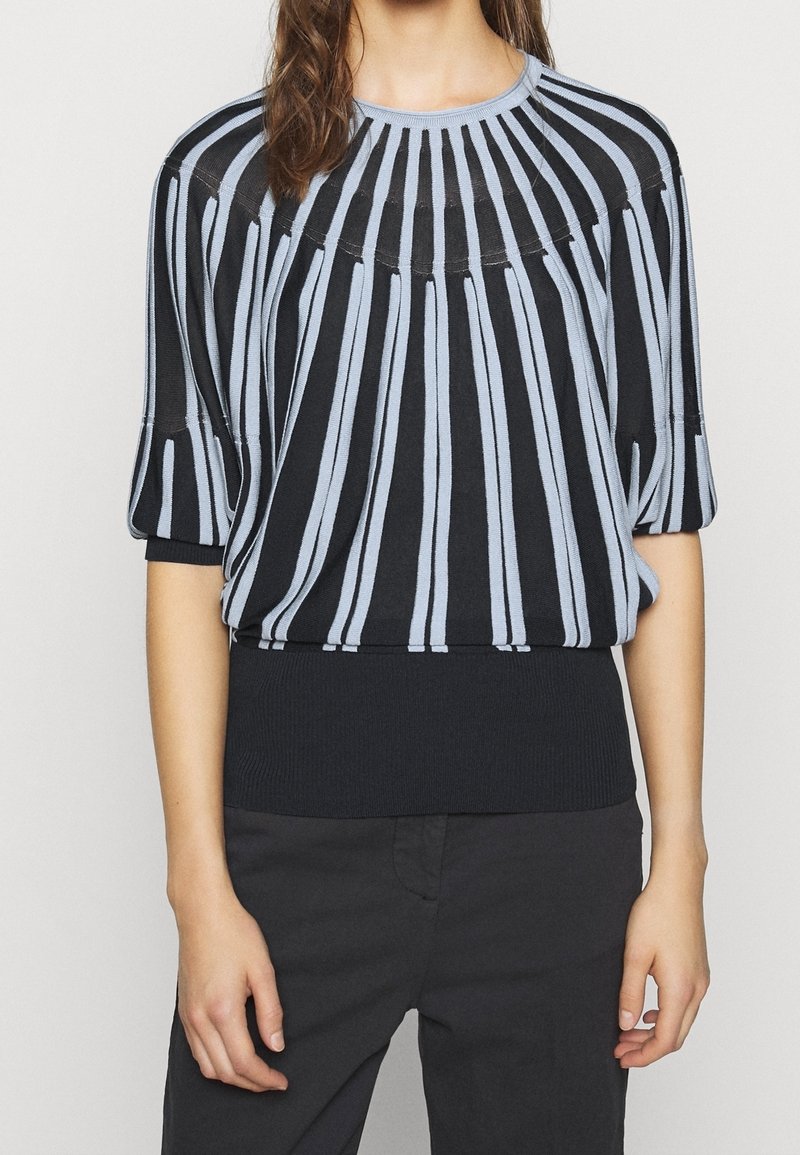 Czarny i jasnoniebieski sweter dzianinowy w paski z krótkimi rękawami i ściągaczem na dole. Posiada pionowe paski na korpusie i gładką teksturę.