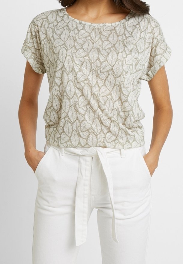 Lichtgroene top met bladpatroon, korte mouwen, relaxte pasvorm, ronde hals, gecombineerd met hoge witte broek met een gestrikt tailleband.