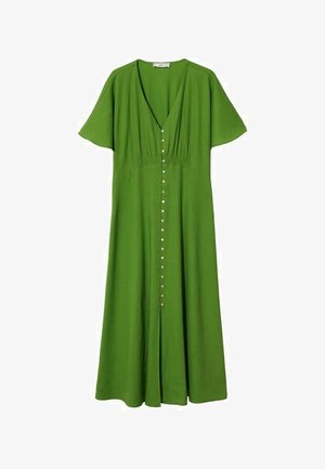 Femme portant une robe midi verte avec des manches courtes papillonnantes et des boutons sur le devant, associée à des sandales noires à talons ouverts avec des boucles.