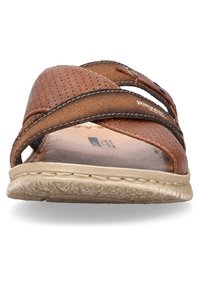 Sandale en cuir marron avec un design à brides croisées, texture perforée, semelle intérieure beige et semelle en caoutchouc avec un motif texturé pour l'adhérence.