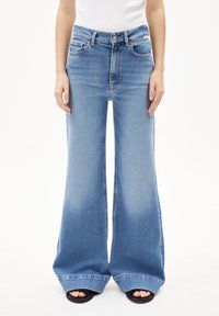 Lichtblauwe wijde jeans gemaakt van denim, met een hoge taille, contrasterende stiksels en een subtiele vervaging bij de zoom.